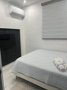a white bedroom with a bed and a window at MarAzul Ocean View in Cabo Rojo