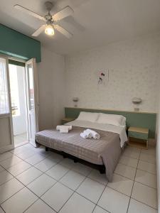 a bedroom with a bed with towels on it at Hotel Roma in Cattolica