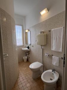 a bathroom with a toilet and a sink at Hotel Roma in Cattolica +44 photos