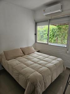 a bed in a room with a window and a mattressituresitures at La Juliet in Colonia del Sacramento