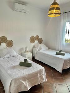 sypialnia z 2 łóżkami i żyrandolem w obiekcie Casa rural Villa Miradri w mieście Torrox