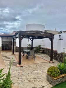drewniana pergola ze stołem i krzesłami na patio w obiekcie Casa rural Villa Miradri w mieście Torrox +14 zdjęć