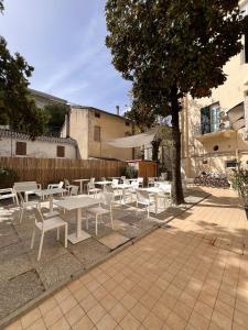 a group of white tables and chairs on a patio at Hotel Roma in Cattolica