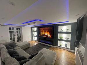a living room with a couch and a fireplace at Lupin Cottage Hot Tub Hide Out Dog Friendly in Weymouth