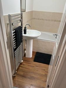 a bathroom with a sink and a bath tub at Lupin Cottage Hot Tub Hide Out Dog Friendly in Weymouth +2 photos