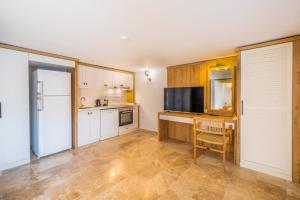 een keuken met witte kasten, een tafel en een koelkast bij White Garden Villas Studio Patara in Kas +2 foto's