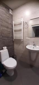 ein Badezimmer mit einer weißen Toilette und einem Waschbecken in der Unterkunft Tbilisi House in Tbilisi City