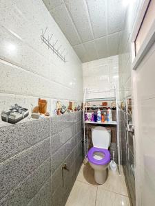 a bathroom with a toilet with a purple toilet seat at Surf and Stay Anza - Surf Territory in Agadir +35 photos