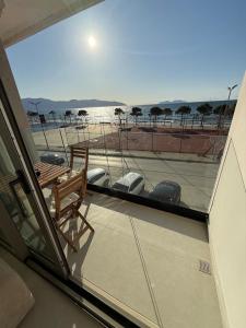 a balcony with a chair and a view of the ocean at Solea Apartment in Vlorë
