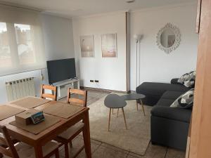 a living room with a couch and a table at Ático Jovellanos in Gijón