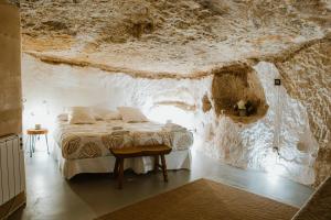 una camera con un letto in una parete di roccia di Casa Cueva Las Tinajas de Naya ad Alcalá del Júcar