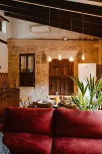 a living room with a red couch and a kitchen at Casa Rural Las Tinajas de Naya in Alcalá del Júcar