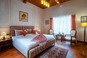 una camera da letto con un letto, un tavolo e delle sedie di Hotel Crags Dalhousie a Dalhousie