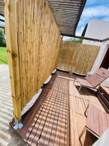 une terrasse en bois avec des bancs et une clôture en bois dans l'établissement Habitación en el campo con baño privado en Puerto Pollensa, à El Port
