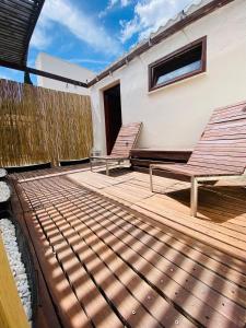 une terrasse en bois avec deux bancs et une clôture dans l'établissement Habitación en el campo con baño privado en Puerto Pollensa, à El Port
