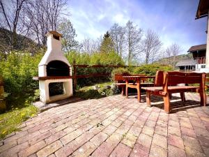 twee banken en een pizzaoven op een terras bij Gerhards Landhaus in Wagrain