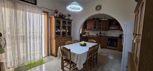 a kitchen with a table with a white table cloth at Lourdes House in San Ġwann