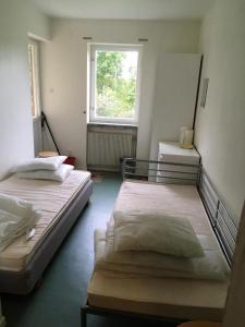 two beds in a room with a window at Hostel Svedjegården in Kristinehamn
