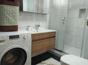 a bathroom with a washing machine and a sink at Villa Kumsal in Kusadası