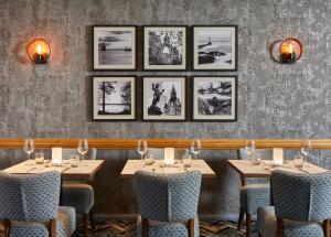 a row of tables in a restaurant with pictures on the wall at Leonardo Inn Aberdeen Airport in Dyce