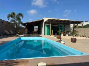 a swimming pool in front of a house at Vila dos ventos in Marataizes