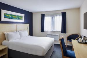 a hotel room with a bed and a desk at Leonardo Inn Aberdeen Airport in Dyce