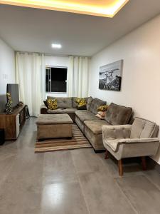 a living room with a couch and two chairs at Vila dos ventos in Marataizes