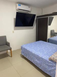 a bedroom with a bed and a tv on the wall at Hospedaje en San Nicolás in San Nicolás de los Arroyos