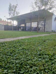 a building with a grassy yard with a sidewalk at Hospedaje en San Nicolás in San Nicolás de los Arroyos +1 photo