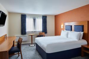 a hotel room with a large bed and a desk at Leonardo Inn Aberdeen Airport in Dyce