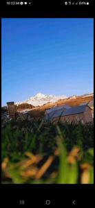 una vista de una montaña desde un campo de hierba en Guesthouse Irma, en Mestia