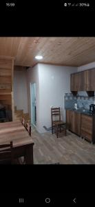 Una cocina con una mesa de madera y un comedor. en Guesthouse Irma, en Mestia