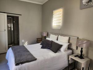 Un dormitorio con una cama con sábanas y almohadas blancas. en Sleep At Solomon 8A, en Kimberley