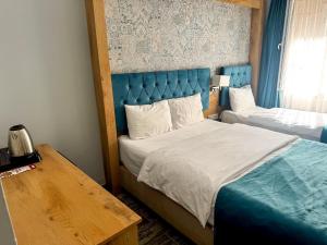 a bedroom with two beds with a blue headboard and a table at Miss City Hotel Taksim in Istanbul +98 photos