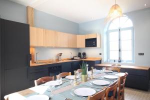 een keuken met een lange tafel met stoelen en een eetkamer bij Passage du Marché in Blainville-Crevon