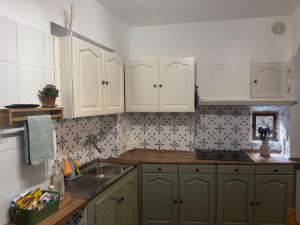 une cuisine avec des armoires blanches et un évier dans l'établissement Casa Montagna, à Scanno