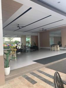 a lobby with tables and chairs in a building at Cheers SMDC Condominium in Marilao