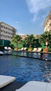 a large swimming pool with palm trees in a building at Cheers SMDC Condominium in Marilao