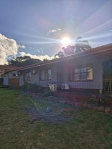 a house with the sun setting behind it at Tettey Happy Home in Durban