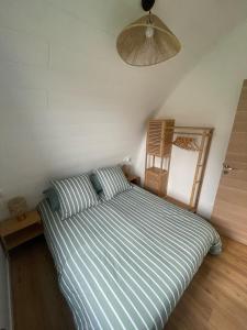 a bedroom with a bed with a striped comforter at Ecolodge in Trébeurden