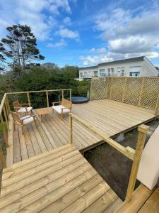 a wooden deck with a bench and a table at Ecolodge in Trébeurden +10 photos