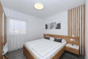a bedroom with a large bed and a window at Apartmani Cicak in Vir