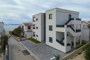 an apartment building with balconies on a street at Apartmani Cicak in Vir