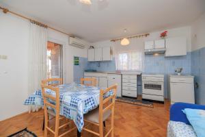 a kitchen with a table and chairs in a room at Apartments Kata in Malinska