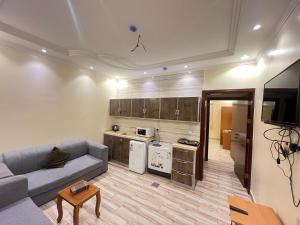 uma sala de estar com um sofá e uma cozinha em Waha Residences-شقق الواحة em Al Madinah