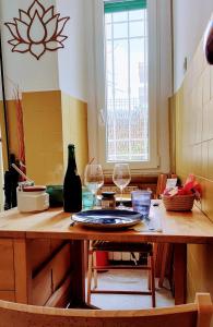 a kitchen with a table with two wine glasses on it at OstiaByTheSeaCozyBedroom in Lido di Ostia +15 photos