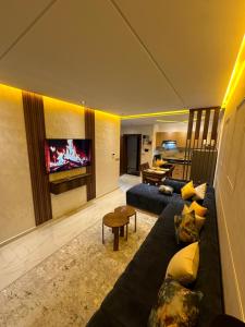 a living room with a couch and a tv at Appartement lumineux, tout confort à deux pas de la plage de Mehdia in Plage de Mehdia