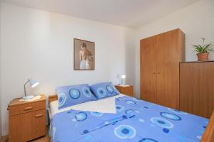 a bedroom with a blue bed with blue pillows at Apartments Kata in Malinska