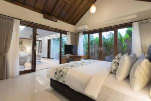 1 dormitorio con 1 cama grande y puerta corredera de cristal en Villa Ciwuwi Balangan by Nagisa Bali, en Jimbaran 41 fotos más