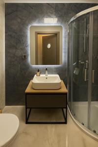 a bathroom with a sink and a shower at Nowa Dzielnica Cztery Apartamenty przy Tężni in Busko-Zdrój +45 photos